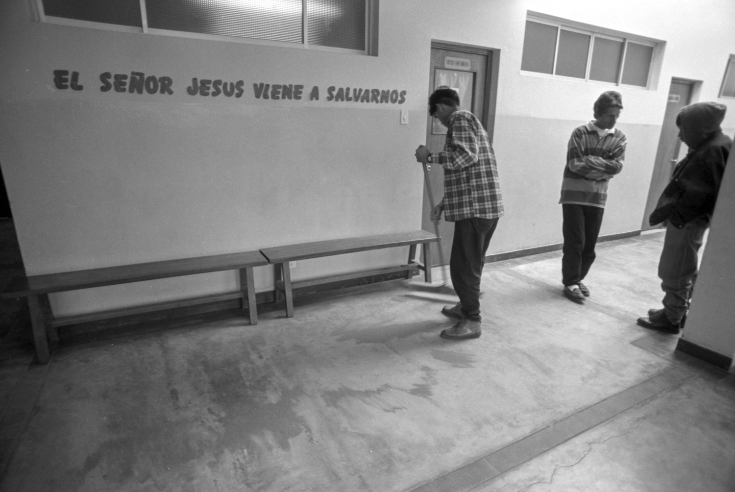 Julio, 1996. Lucho Jara (centro) y Donato (derecha, con cabeza cubierta) conversan en las puertas de un consultorio de un centro médico parroquial en San Juan de Miraflores.