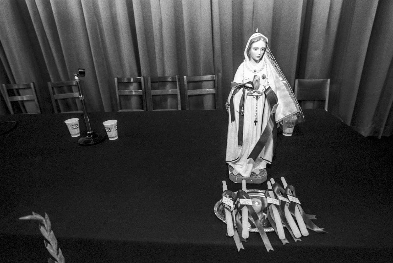 Octubre, 1996.Una pequeña figura de la Virgen de la Puerta junto a velas se observan en una mesa luego de una charla sobre la vida con el VIH en el auditorio de un centro escolar en Jesús María, Lima.