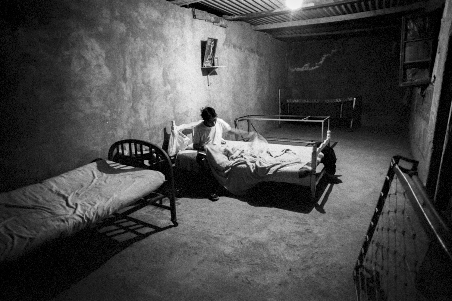 Marzo, 1994. un hombre VIH positivo prepara su cama en la habitación de un albergue en Villa María del Triunfo.