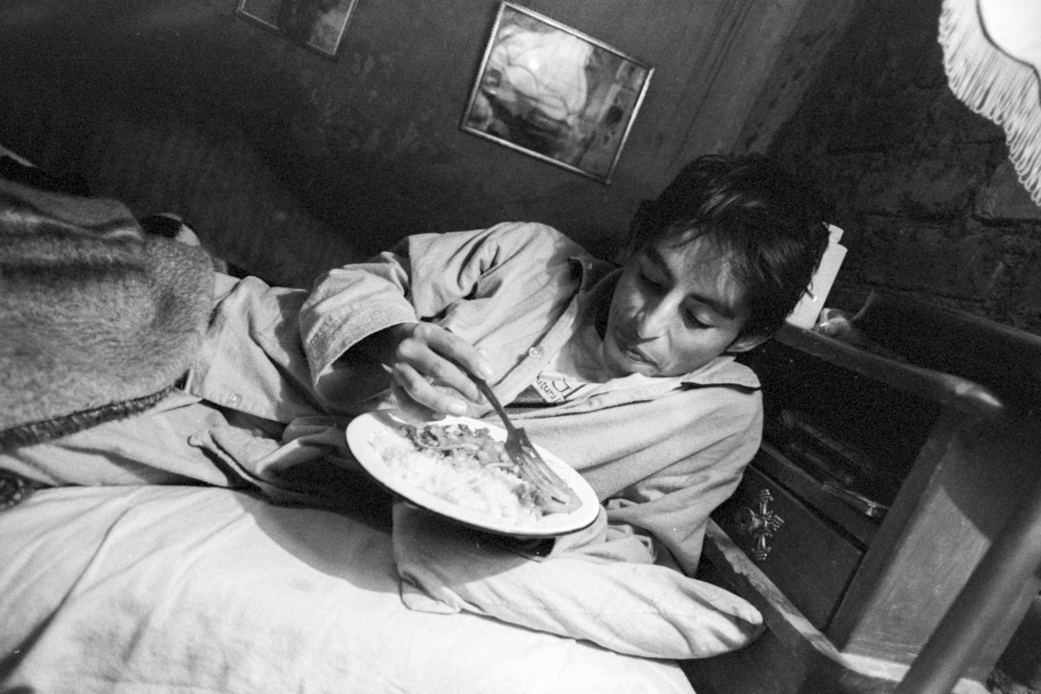 Circa, 1996. Mario, con VIH-SIDA, se alimenta en su cama mientras convalece.