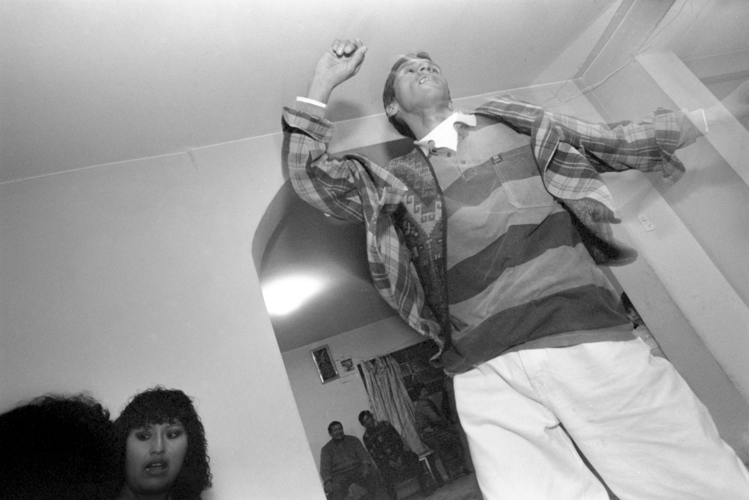 Octubre, 1996. Lucho Jara, coordinador del Grupo de Ayuda Mutua (GAM) Vida Nueva, salta mientras baila en una celebración para recaudar fondos para el tratamiento de salud de un compañero del GAM.